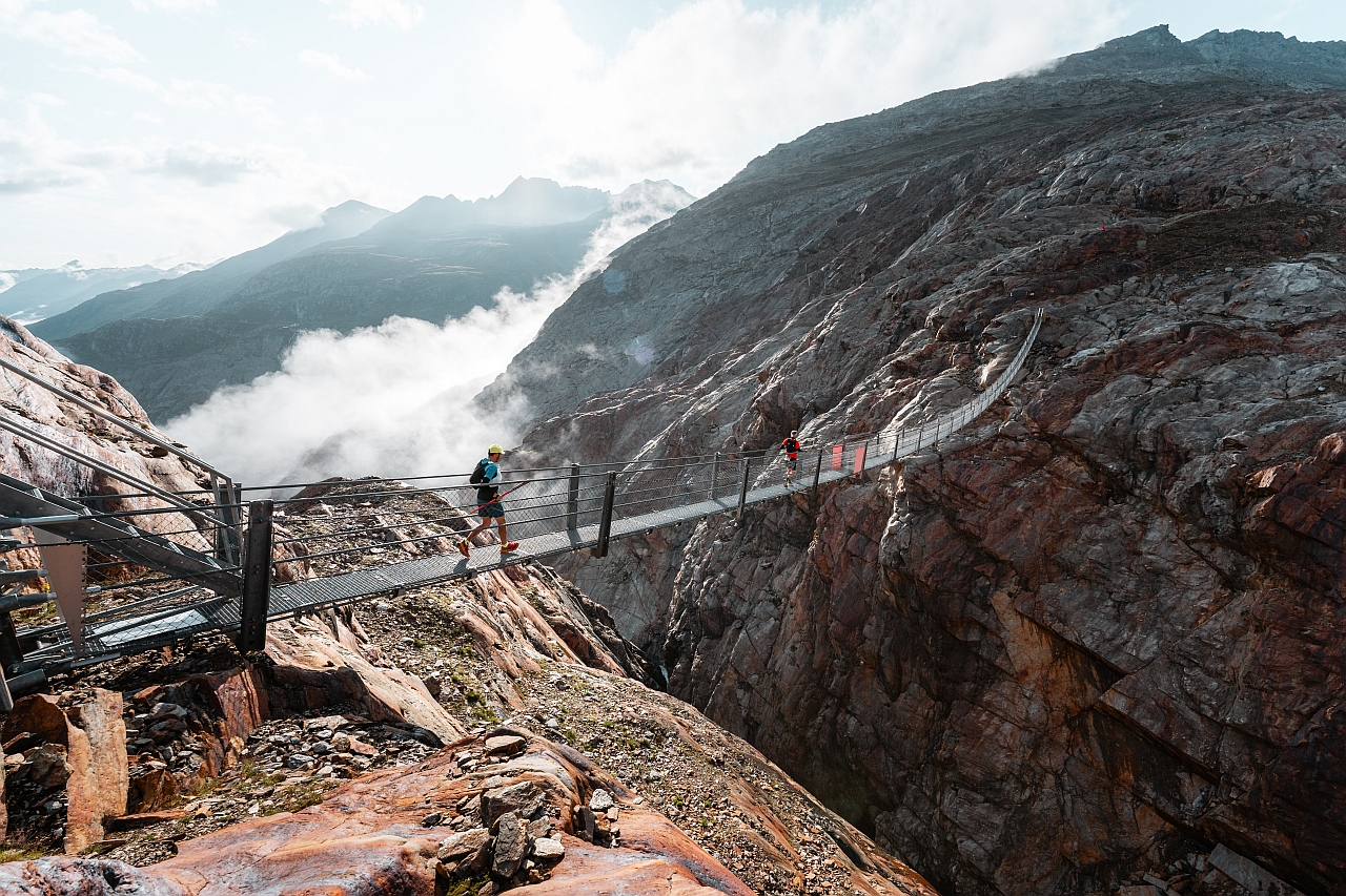 Trailrunner auf einer Hängebrücke in hochalpiner Landschaft bei Gurgl